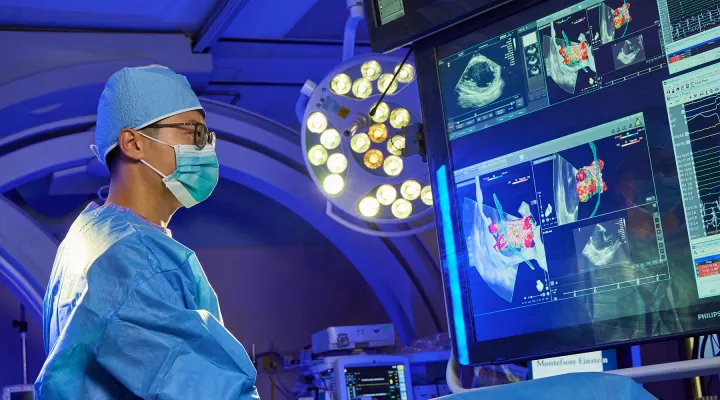 A physician in a lab looking at a screen