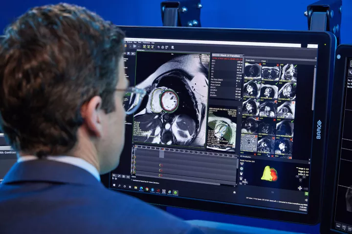 A physician in a lab looking at a screen