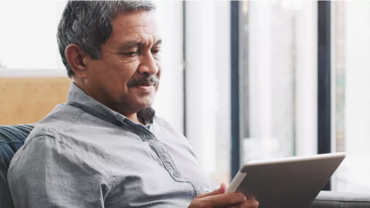 Man in button down shirt reading tablet