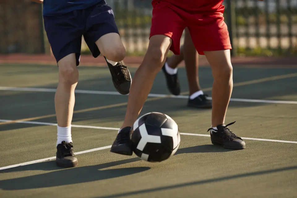 The legs of two men playing soccer
